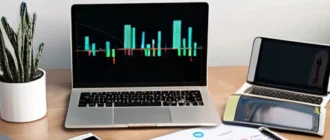 Home office with digital devices and charts representing passive income and financial automation